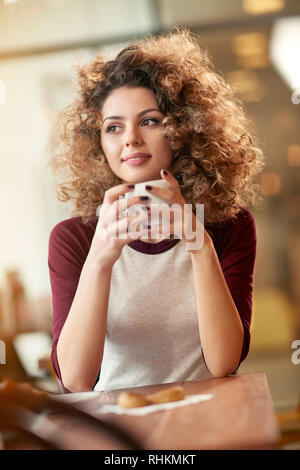 Attractive female with cup of coffee in cafe Stock Photo