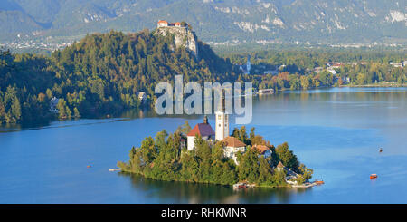 Panoramic view of the Church Of The Assumption on Blejski Otok with Bled Castle, Lake Bled, Bled, Gorenjska, Slovenia. Stock Photo