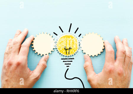 Concept photo of revealing an idea, finding the right solution during creative process. cogeheel with bright light bulb Stock Photo