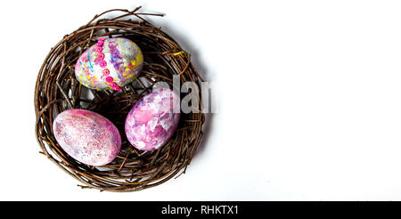 Easter eggs in a wicker nest top view Stock Photo