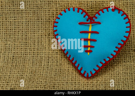 Valentine Day template, one handmade blue foam sheet stitched toy heart on jute canvas, close up, high angle view. Love, relationship, Valentines Day, Stock Photo