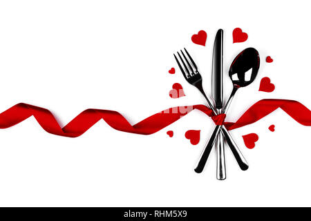 Cutlery set tied with silk ribbon and hearts isolated on white background Valentine day dinner concept Stock Photo