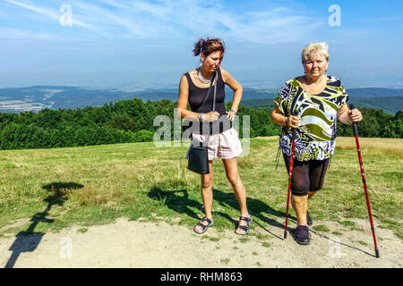 Women on a trip, Nordic walking, mountain meadow in the White Carpathians Mountains, Velka Javorina, Czech Slovak border Stock Photo