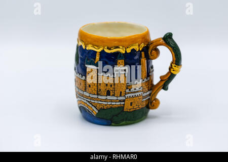 a hand made coffee mug with bkue and orange painted details Stock Photo