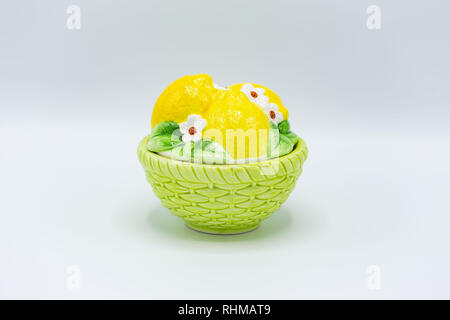 a round candy dish with green bottom and lemons on the lid Stock Photo
