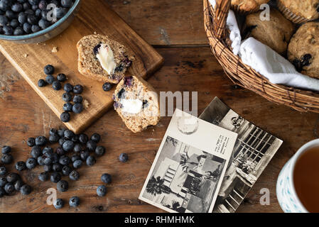 muffins and vintage postcards on wood table Stock Photo
