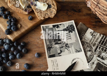 muffins and vintage postcards on wood table Stock Photo