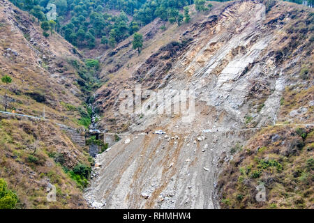 Mountain landslide in an environmentally hazardous area blocking road. Stock Photo