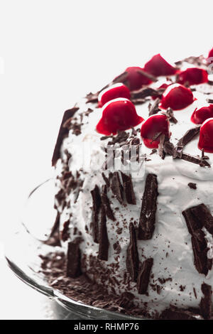 Black Forest Cake close-up. White background - Red cherries, chocolate and whipped cream. Home made Foret Noire cake. Vertical view Stock Photo