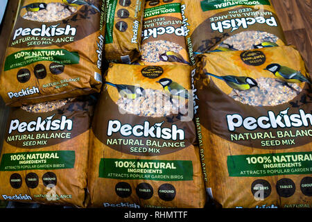 A stack of large bags of Peckish brand wild bird food for sale in a garden centre in North Yorkshire England Stock Photo