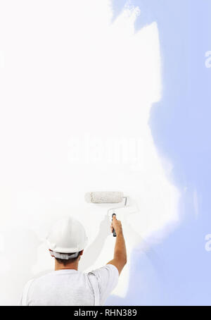 Rear view of painter man with paint roller painting on blank wall, isolated on white, copy space template Stock Photo