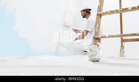 painter man at work, with wooden ladder and  blank wall for copy space, web banner template Stock Photo