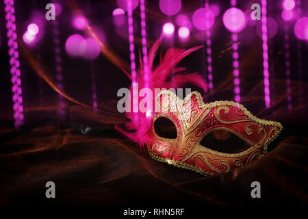 Photo of elegant and delicate gold, red venetian mask over dark velvet and silk background Stock Photo