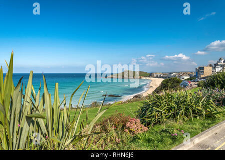 Looking across Porthmeor beach towards The Island from Beach road St.ives Cornwall UK Europe on a beautiful warm summer day with blue sky and sea Stock Photo