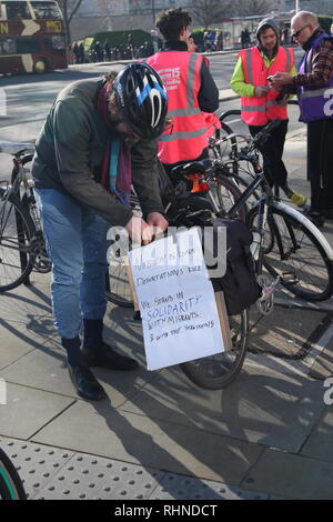 London, UK, February 3rd 2019. A cyclist taking part in the protest attaches a notice to his bike. It Says: 'no one is illegal. Deportations Kill.We stand in solidarity with migrants and with the Stansted 15'. Cyclists gather in central London to take part in a ten mile ride in support of the ‘Stansted 15’. The ‘Stansted 15’ are a group of protesters who surrounded an aircraft at Stansted airport in 2017 to prevent it being used to carry out a deportation. The 15 have been found guilty of terrorism related charges and will be sentenced in Chelmsford on February the 6th. Roland Ravenhill/Alam Stock Photo