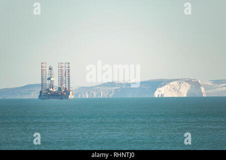 An ENSCO 72 oil rig against a backdrop of the Isle of Wight. The rig will be drilling to a depth of more than 1000 metres into the seabed in th Stock Photo