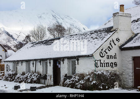 Crafts and Things shop and café covered in snow on a cold winters day at Glencoe Village, Highlands, Scotland in winter