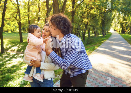 Happy family standing playing in the park.  Stock Photo