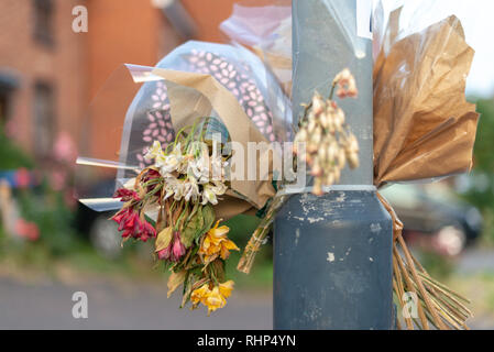 wilting flowers tied to lamp post to mark scene of accident Stock Photo