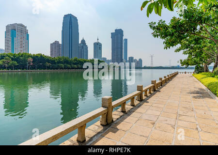 XIAMEN, CHINA -OCTOBER 09: Riverside path at Bailuzhou park with city buildings in the background on October 09, 2018 in Xiamen Stock Photo