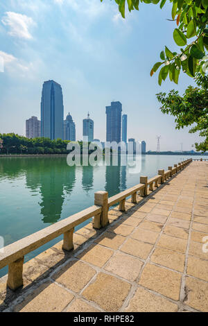 XIAMEN, CHINA -OCTOBER 09: Riverside path at Bailuzhou park with city buildings in the background on October 09, 2018 in Xiamen Stock Photo