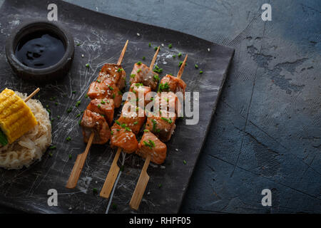 Salmon skewers with miso close view with noodles and corn, copy space. Stock Photo