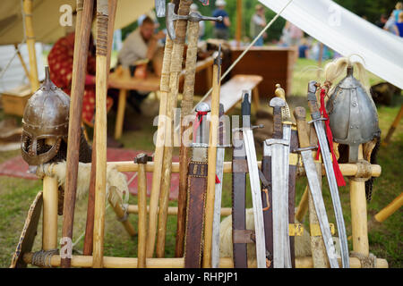 Toy medieval armour, helmets and wooden weapons sold on market stall during annual Medieval Festival, held in Trakai Peninsular Castle. Stock Photo