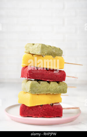Pile of vegan fruit sorbet popsicles on white background Stock Photo