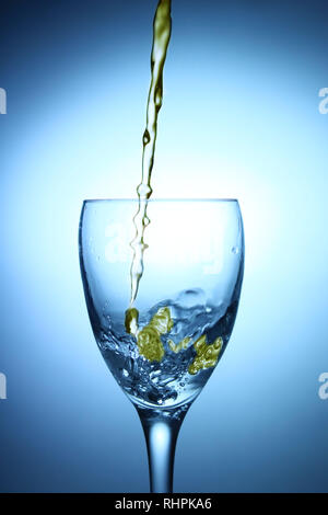 Oil splashing into a glass of water Stock Photo