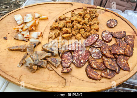 Homemade sausages smoked and dried and other products stand on the table for sale. Stock Photo