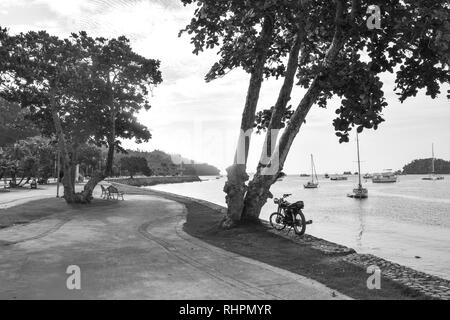 Promenade in Santa Barbara de Samana in front of the ocean with many boats in black and white, dominican repulic Stock Photo