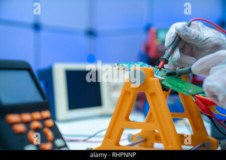 Fixing electronics PCB board in service /  workbench with electronics measuring instruments Stock Photo