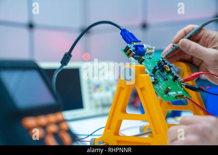 Fixing electronics PCB board in service /  workbench with electronics measuring instruments Stock Photo