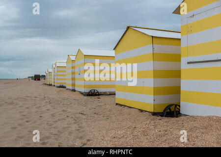 Row of yellow and white beach huts Stock Photo