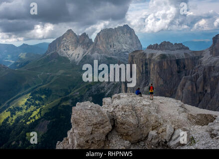 Two hikers taking a rest on top of Sass Pordoi in the Italian Dolomite mountains Stock Photo