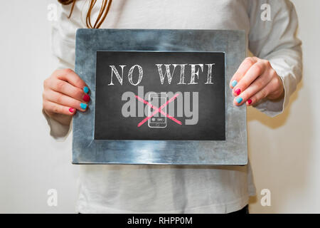 Girl holding up a blackboard with the words No WIFI written in chalk Stock Photo
