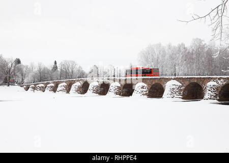 Karlstad, Sweden - January 31, 2019: One red public transport buss on the old stone arch bridge crossing the river Klaralven. Stock Photo