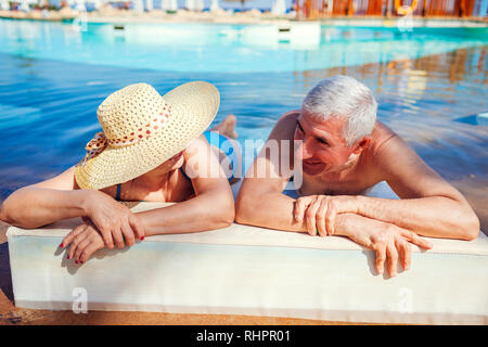 Senior couple relaxing in swimming pool. People enjoying vacation. Valentine's day Stock Photo