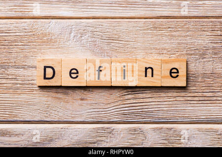 Define word written on wood block. Define text on wooden table for your desing, concept. Stock Photo