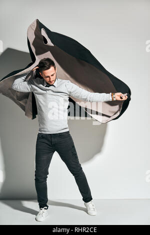 Portrait of a handsome young man dressing coat in rush Stock Photo