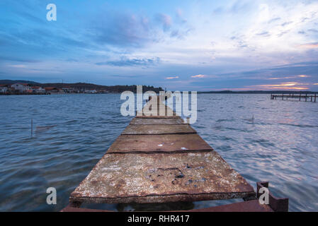 Old rusty bridge in a lake at sunset near Bourgas, Bulgaria . Summer lanscape with beautiful clouds.