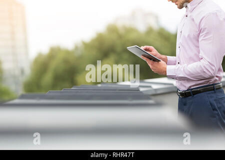 Midsection of businessman using digital tablet in office terrace Stock Photo