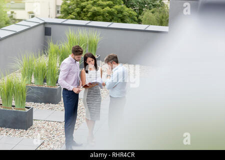 High angle view of colleagues discussing over documents at office terrace Stock Photo