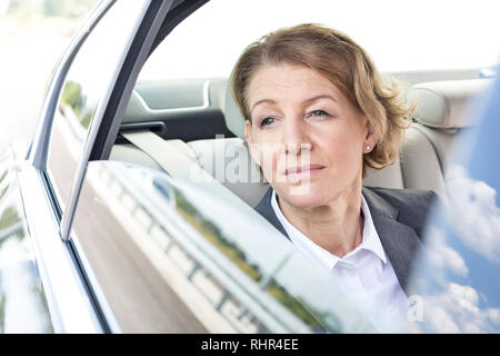 Thoughtful businesswoman looking through window while sitting in car Stock Photo