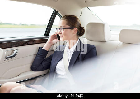 Businesswoman talking on smartphone while sitting in car Stock Photo