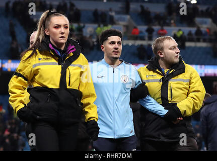 A pitch invader is escorted off the pitch during the Premier League match at the Etihad Stadium, Manchester. Stock Photo