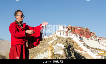 Tibetan Buddhist monk with mala prayer beads in front of Potala Palace, Lhasa, Tibet Stock Photo