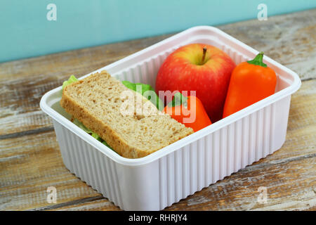 Healthy school lunchbox  containing brown cheese sandwich, crunchy yellow pepper and red apple Stock Photo