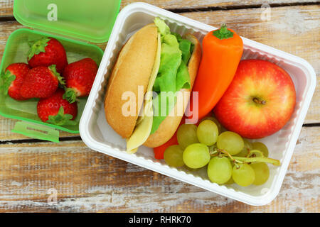 Healthy school lunchbox  containing cheese sandwich with lettuce, crunchy yellow pepper and fresh fruit Stock Photo