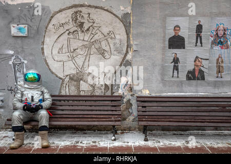 A man dressed as an astronaut suit sitting on a bench on Arbat street in the center of Moscow, Russia Stock Photo